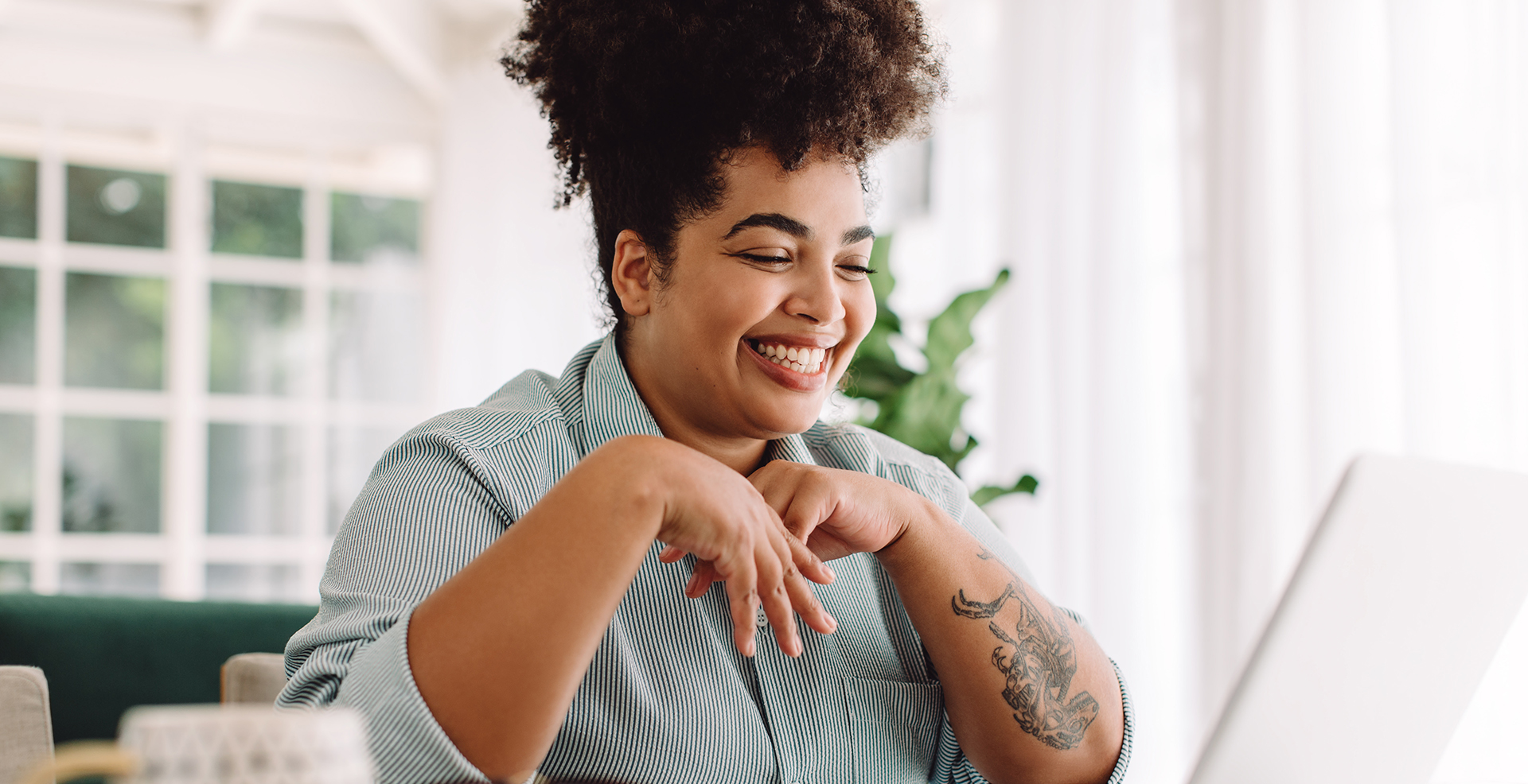 Positive woman video calling using laptop. Businesswoman teleconferencing on laptop while working from home.