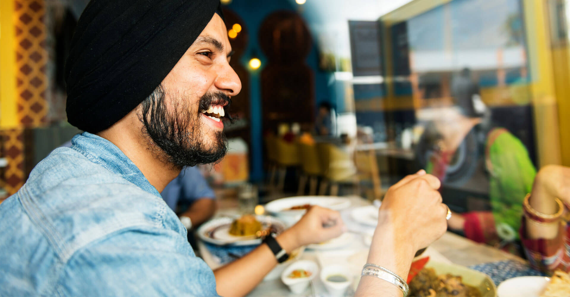 a man enjoy his meal with his friends